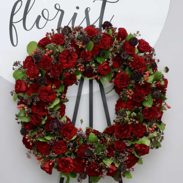 Red rose wreath on a black easel