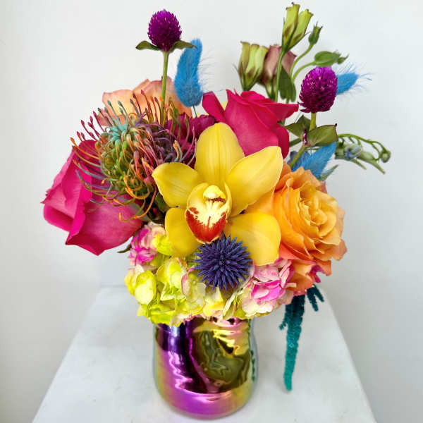 Bright mixed bouquet with orchids, roses, and calla lilies in a metallic vase