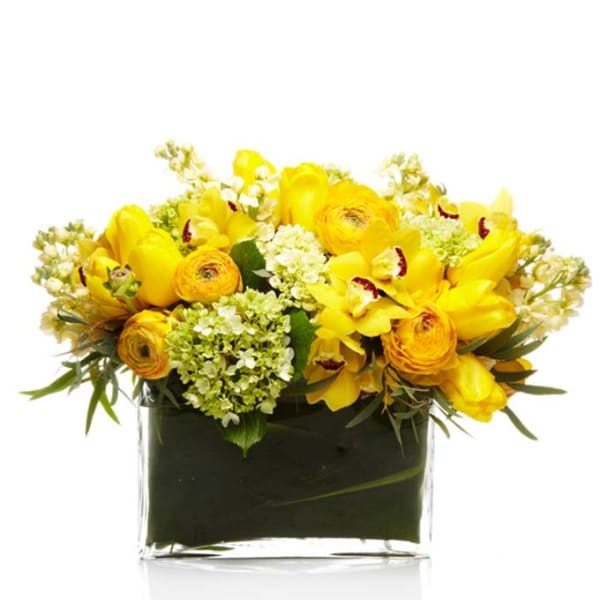 Low yellow flower arrangement in a rectangular clear glass vase