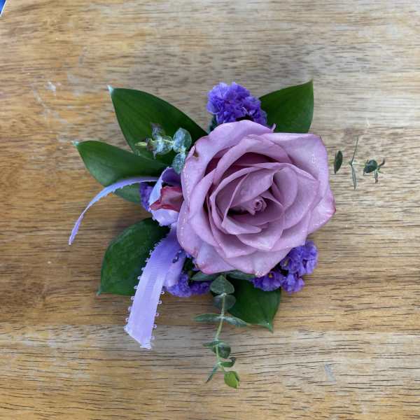 Lavender rose boutonniere with purple filler and ribbon