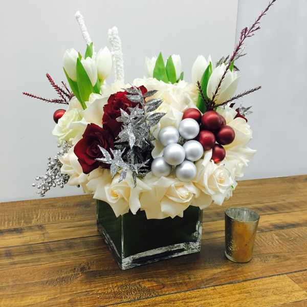 White tulips and roses with red roses in a square vase