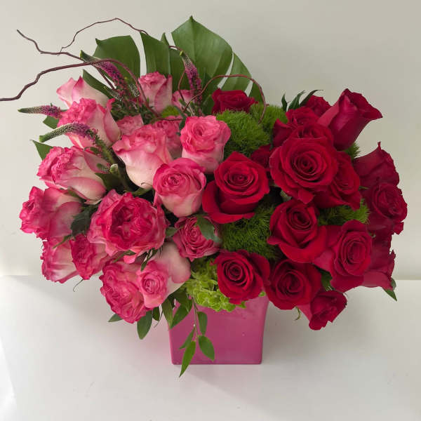 Pink and red rose arrangement in a pink vase