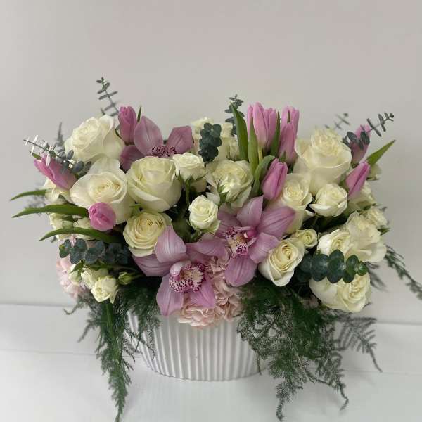 Pink and white floral arrangement in a ribbed white vase