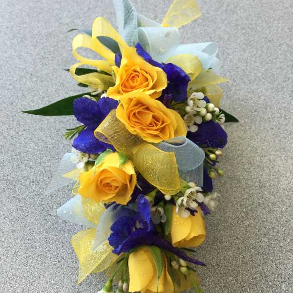 Yellow roses with blue flowers and ribbon in a small bouquet