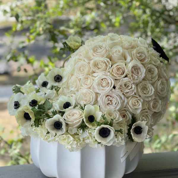 Cream rose bouquet with white anemones in a white vase
