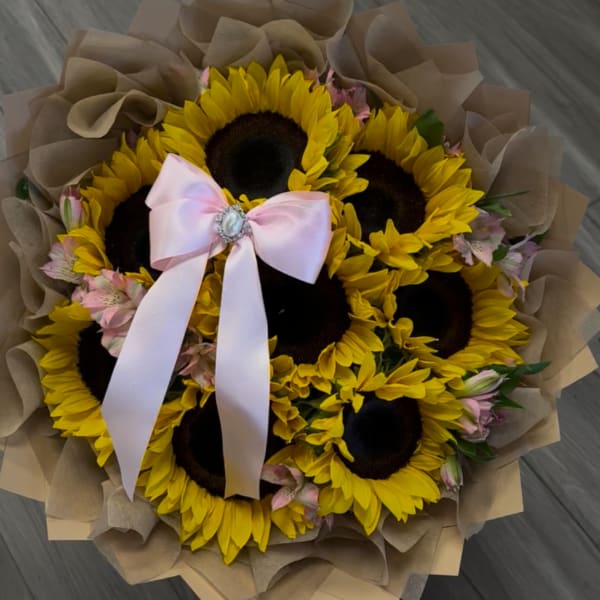 Bouquet of sunflowers with a pink ribbon and brown paper wrap