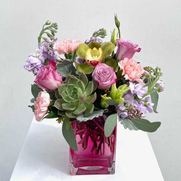 Mixed pink and lavender bouquet in a pink glass vase