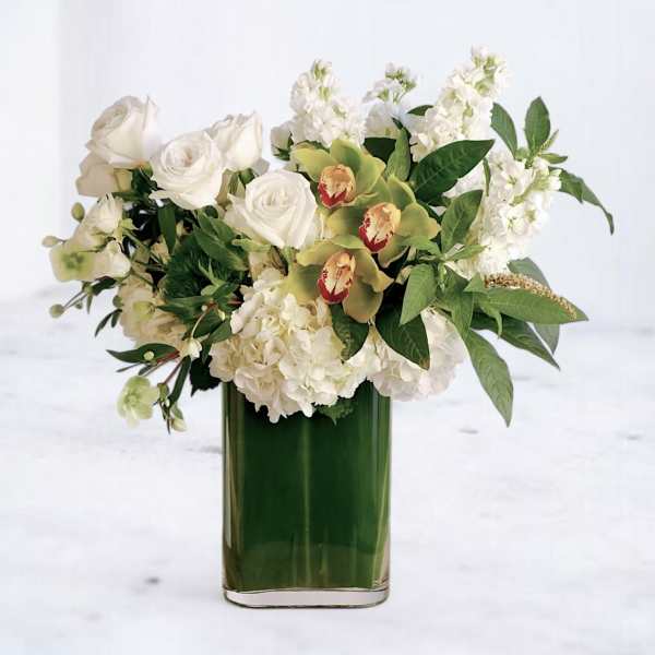 White roses and hydrangeas in a green glass vase