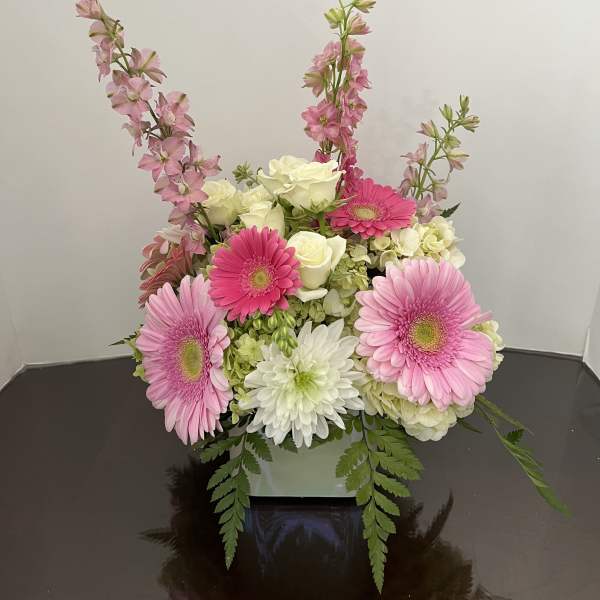 Pink gerberas and white roses in a low square vase