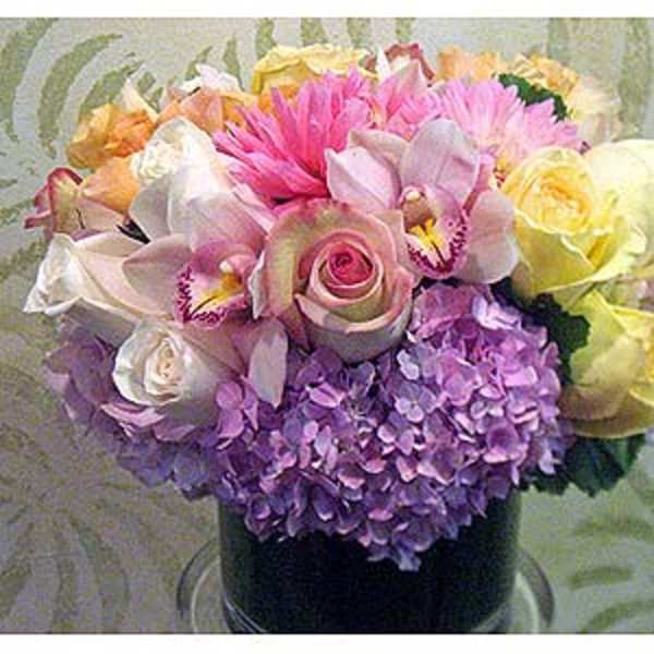 Mixed bouquet with roses, orchids, hydrangeas, and pink blooms in a vase