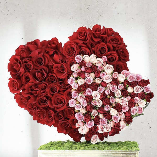 Heart-shaped rose arrangement in red, pink, and white on a rectangular base