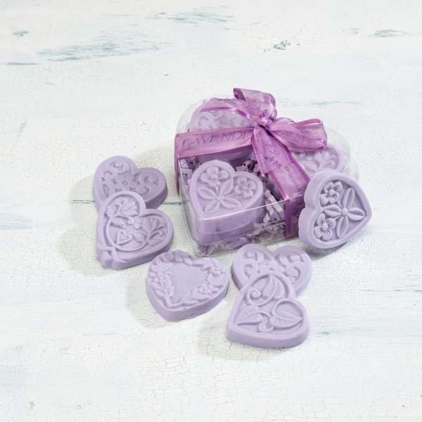 Heart-shaped lavender soaps in a clear heart box with a purple ribbon and soaps scattered around it.