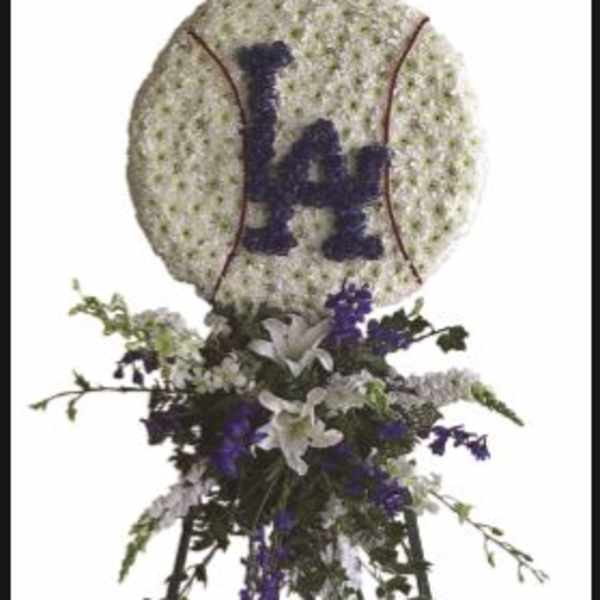 Baseball-shaped floral tribute on an easel with purple and white flowers