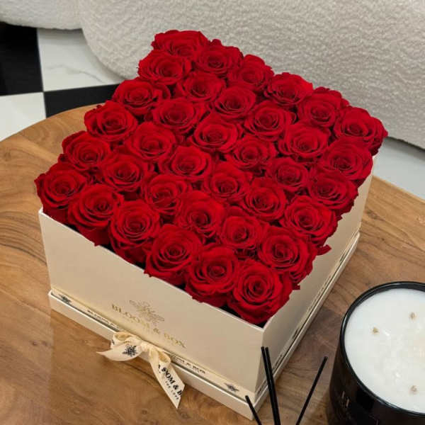 Box of red roses arranged in a square gift box