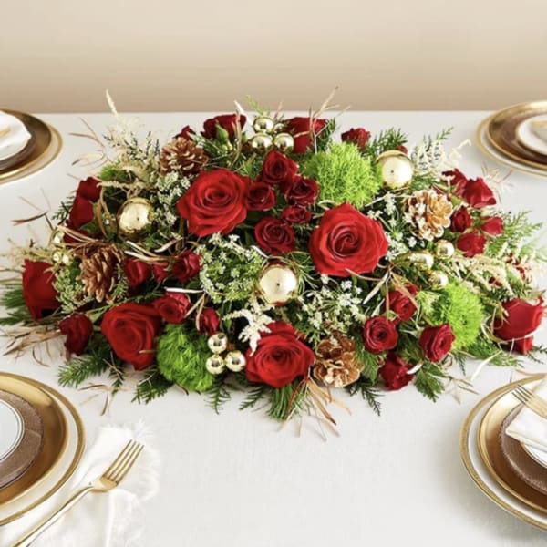 Red rose centerpiece with pinecones and gold ornaments on a table