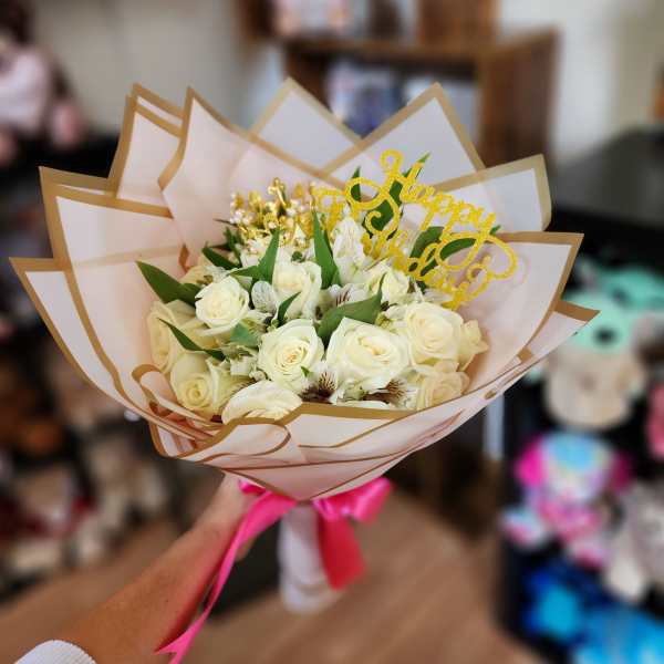 Bouquet of white roses with a gold "Happy Birthday" topper