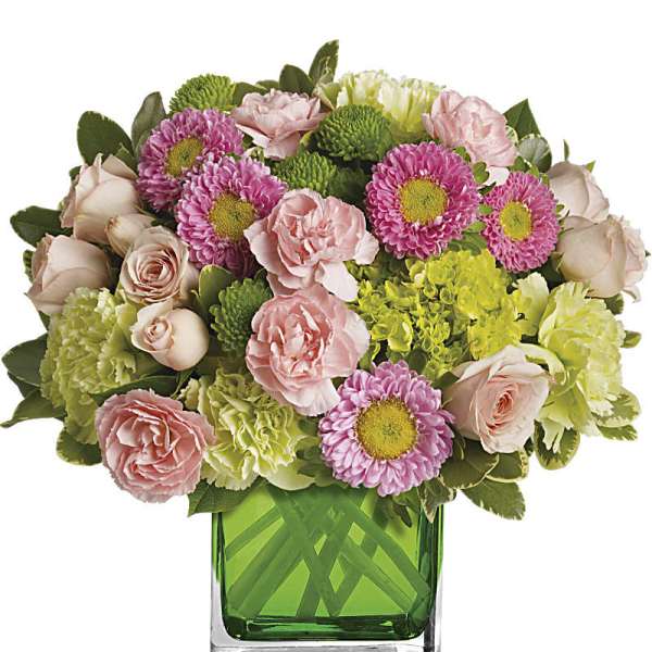 Pink and green mixed bouquet in a square glass vase