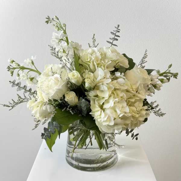 White hydrangea and roses in a clear glass vase