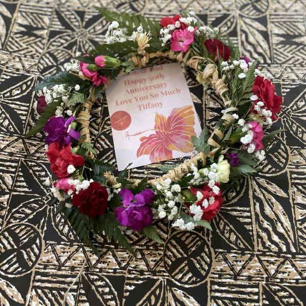 Floral wreath with pink, red, and purple flowers around a card