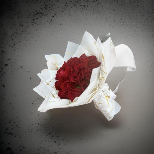 Bouquet of red roses wrapped in white paper