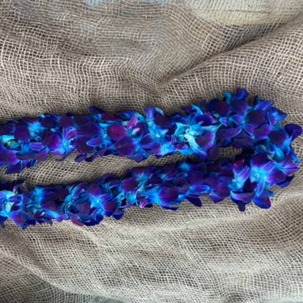 Blue and purple flower lei on burlap fabric