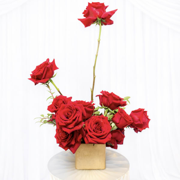 Red roses arranged in a small square vase