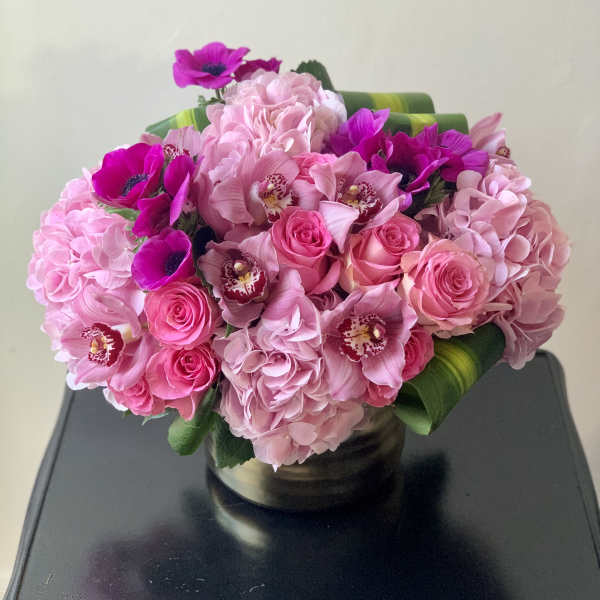 Pink bouquet of roses, hydrangeas, and orchids in a vase
