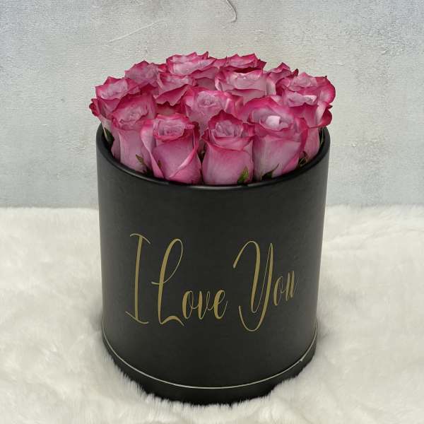 Round black hat box filled with pink roses and gold I Love You text on the front