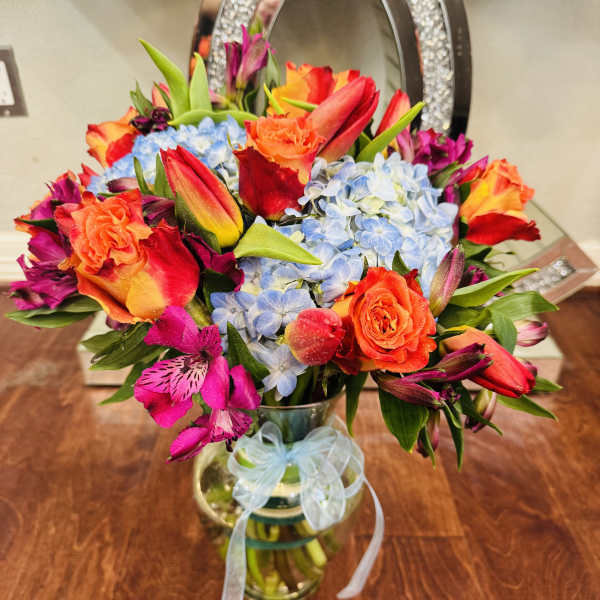 Colorful bouquet of roses, hydrangeas, and alstroemeria in a glass vase