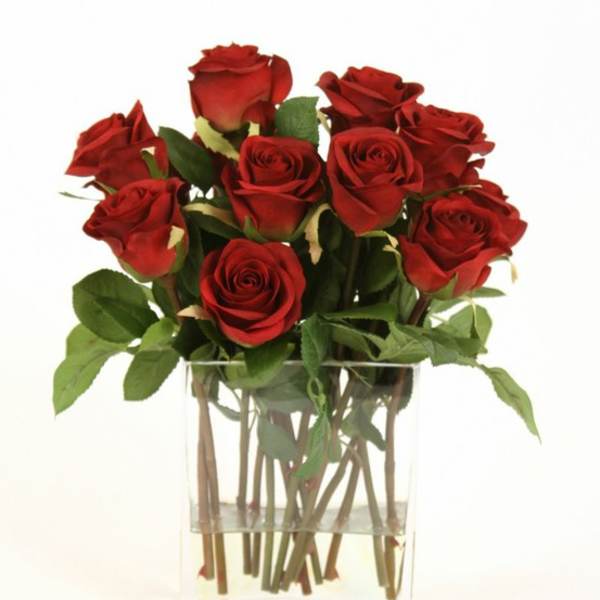 Red roses arranged in a clear glass vase