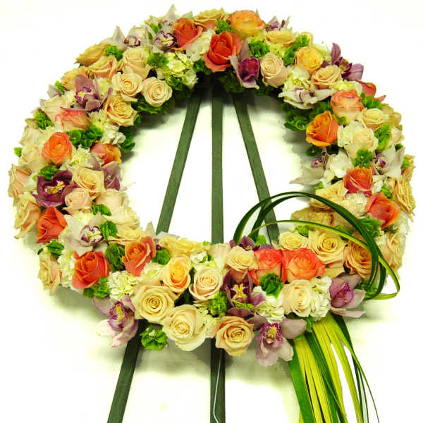 Circular floral wreath of roses and orchids on a stand