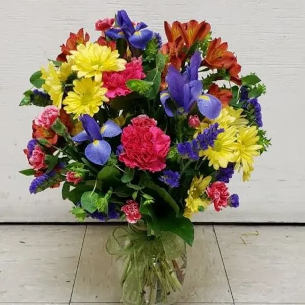 Mixed bouquet of bright flowers in a clear glass vase