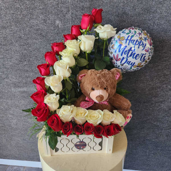 Red and white roses arranged with a teddy bear and a Mother's Day balloon