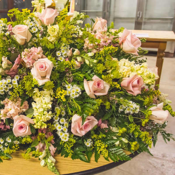 Large low floral arrangement with pale pink roses and white filler flowers