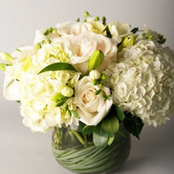 White floral bouquet in a green glass vase