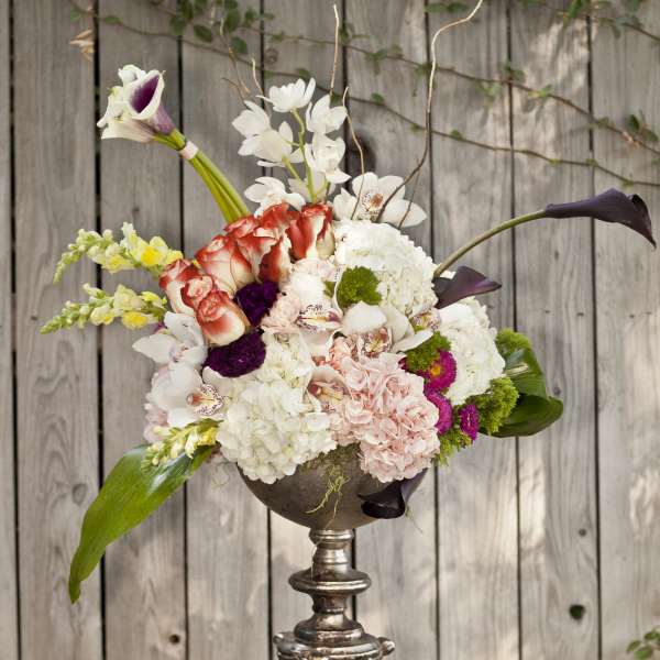 Mixed floral arrangement in a silver pedestal vase with white, pink, and purple blooms