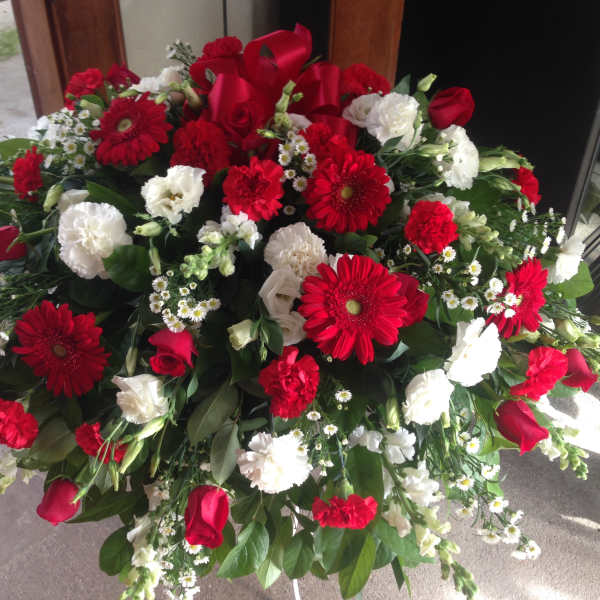 Large red and white floral spray with roses, gerbera daisies, and carnations