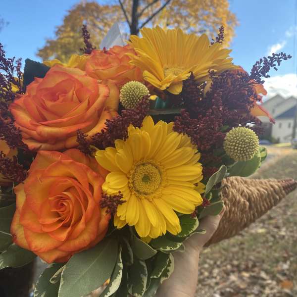 Handheld bouquet of orange roses and yellow gerbera daisies