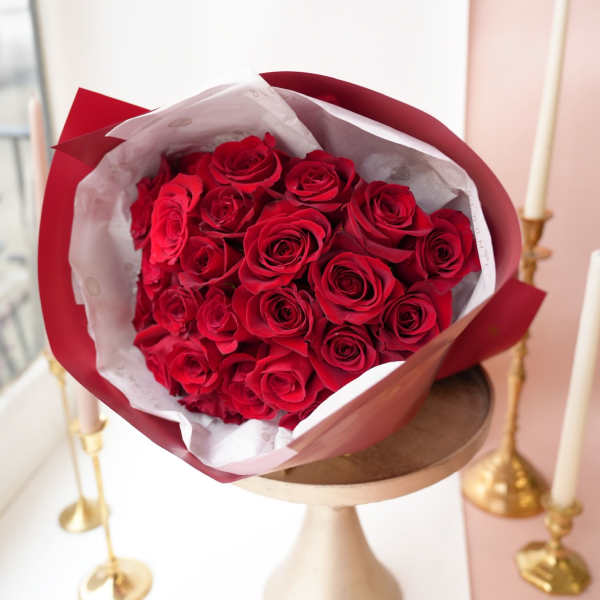 Bouquet of red roses wrapped in red and white paper