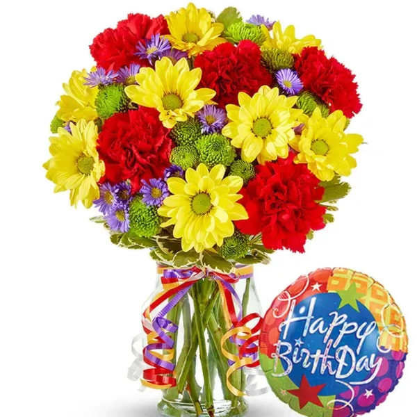 Colorful bouquet of daisies and carnations in a glass vase with a birthday balloon