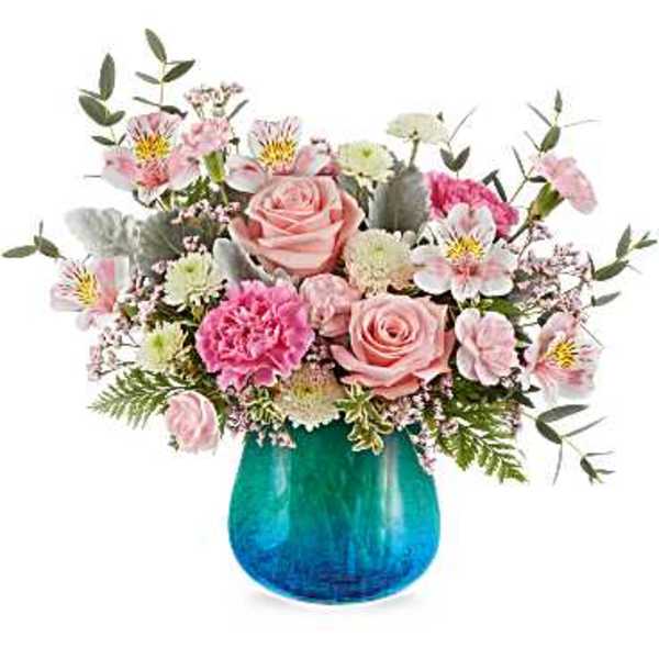 Pink roses and mixed blooms in a blue glass vase