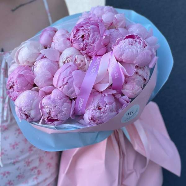 Pink peonies wrapped in pastel blue and pink paper with ribbon