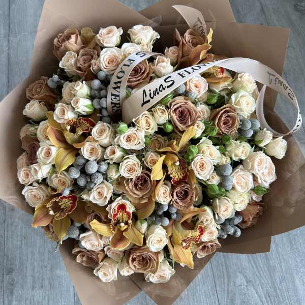 Large bouquet of blush and cream roses with orchids and ribbon