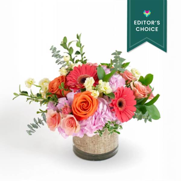 Mixed bouquet of pink and orange flowers in a glass vase