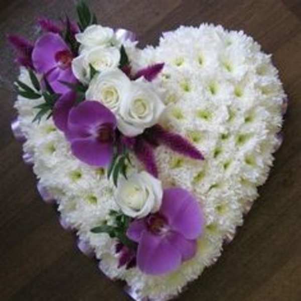 Heart-shaped white floral arrangement with purple orchids and white roses.
