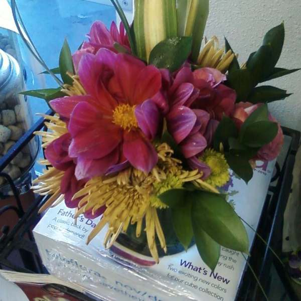 Bouquet of pink and yellow flowers with looping green leaves