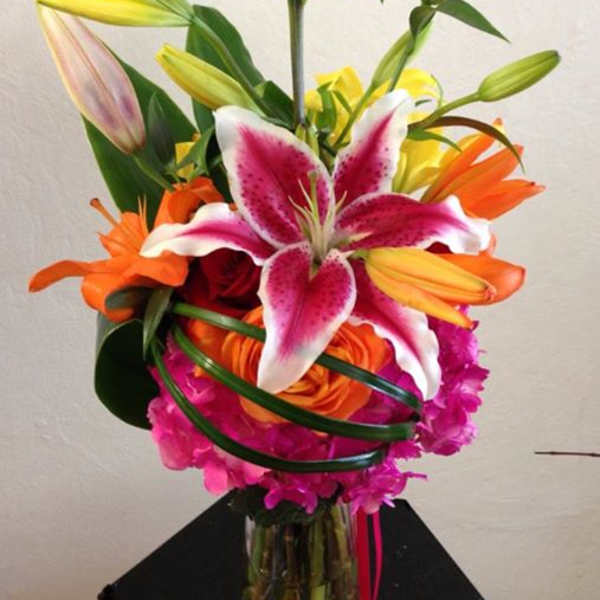 Bright bouquet of lilies and roses in a glass vase