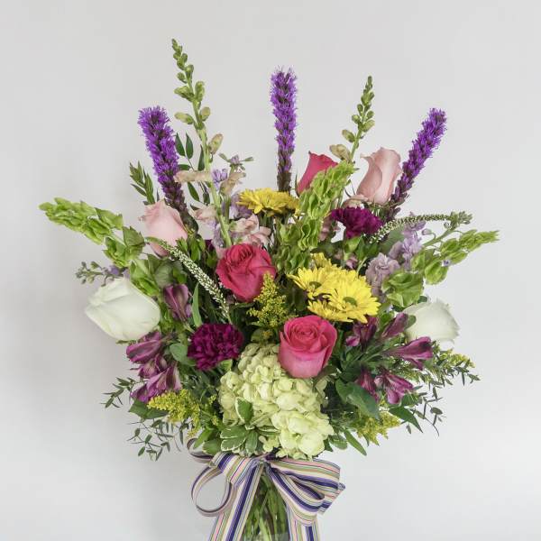 Mixed bouquet in a glass vase with pink, white, yellow, and purple flowers