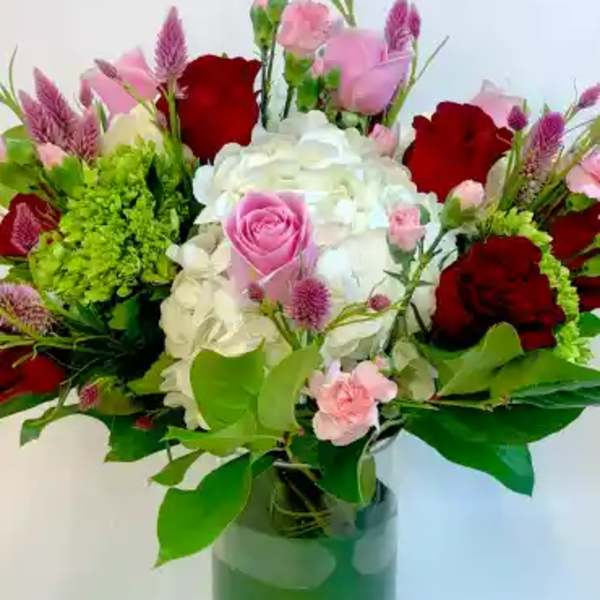 Bouquet of red, pink, and white flowers in a glass vase