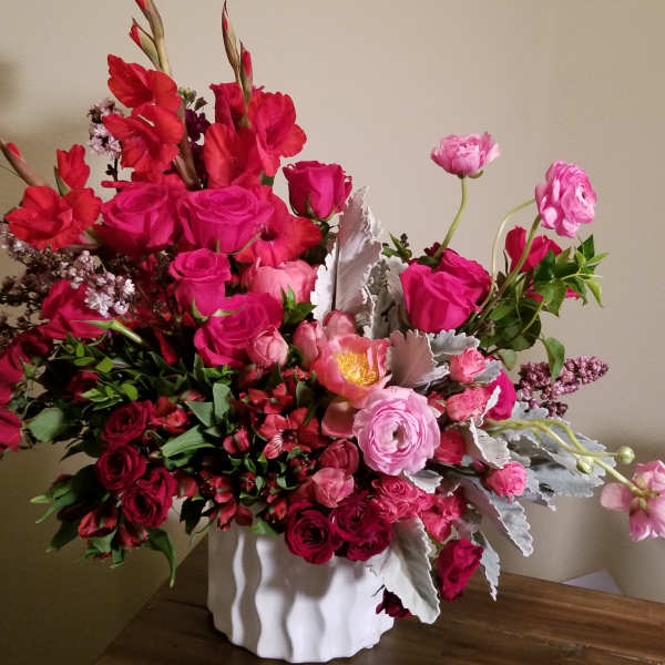 Pink and red mixed flower arrangement in a white vase